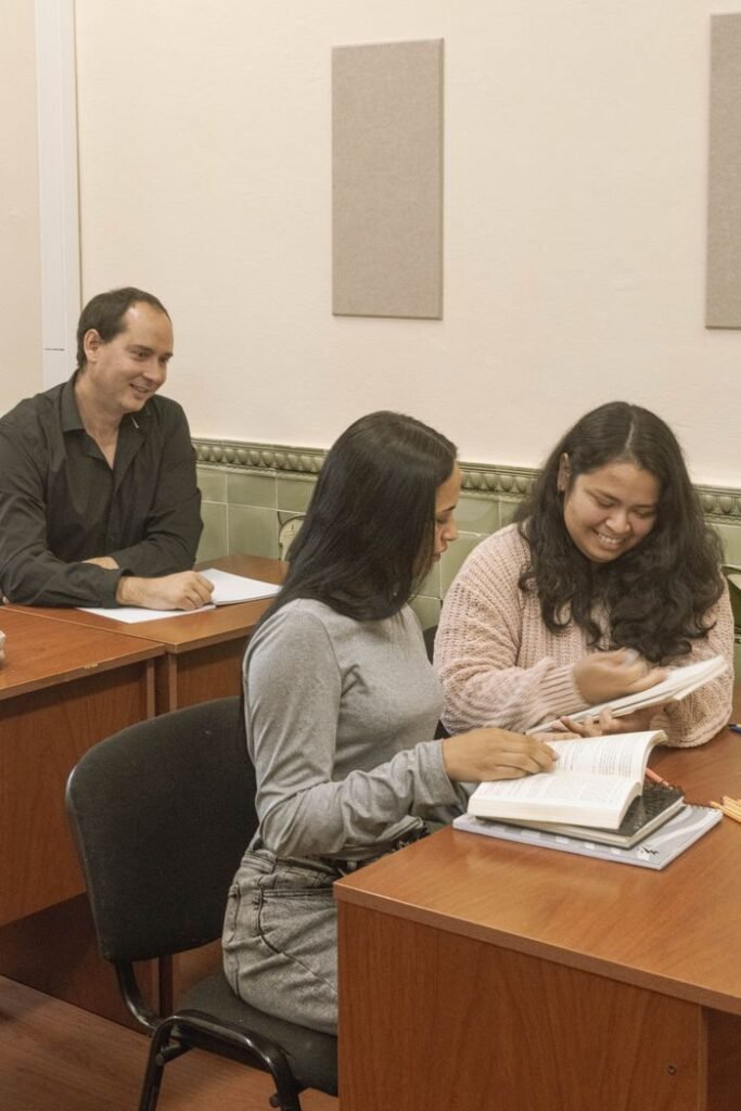 Young adults studying in a warm, indoor classroom environment.